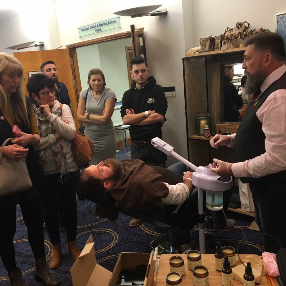 A barbering demonstration with visible attendees watching