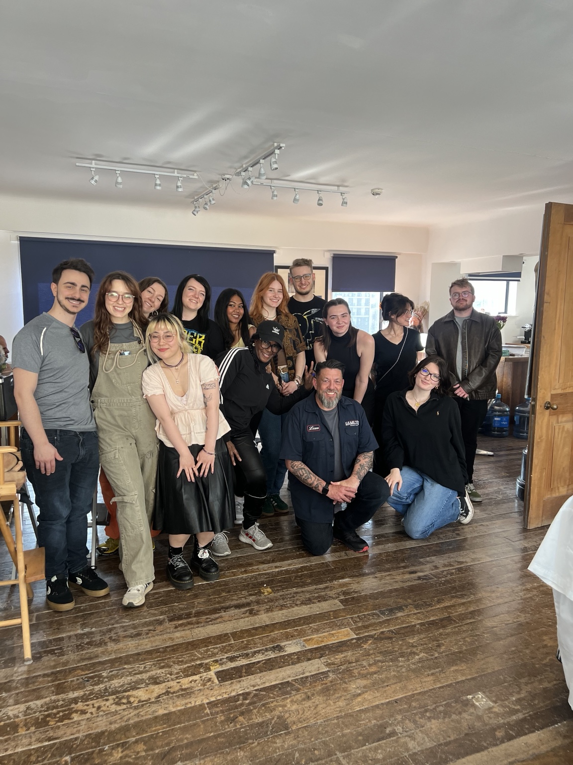 A large group of people photographed together with barbering equipment