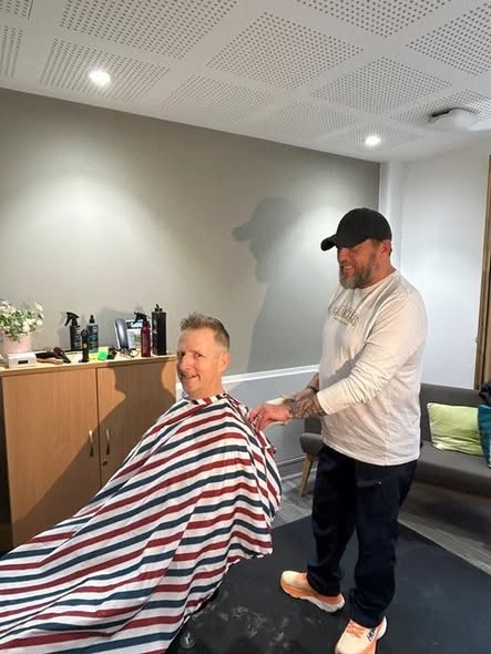 A Hamilton's barber giving a haircut at The Cove Macmillan Support Centre Wellbeing Evening