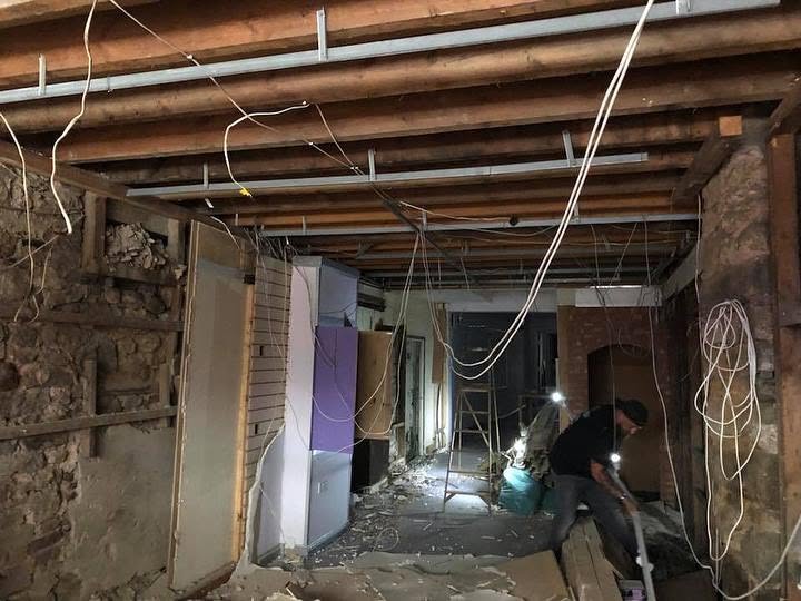 Building work underway inside 24 Fore Street, with a worker clearing the stripped-out interior