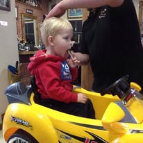 A young child having a haircut in an early Hamilton's shop