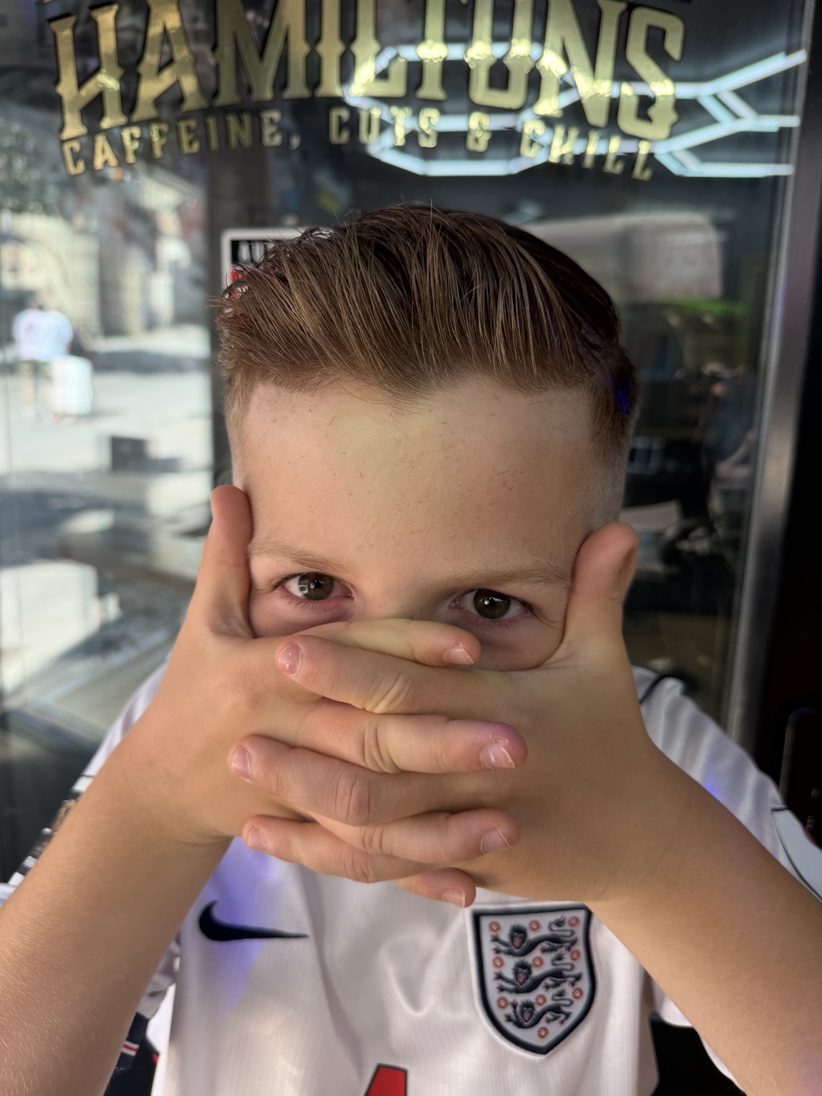 A young boy standing outside the Hamilton's shopfront