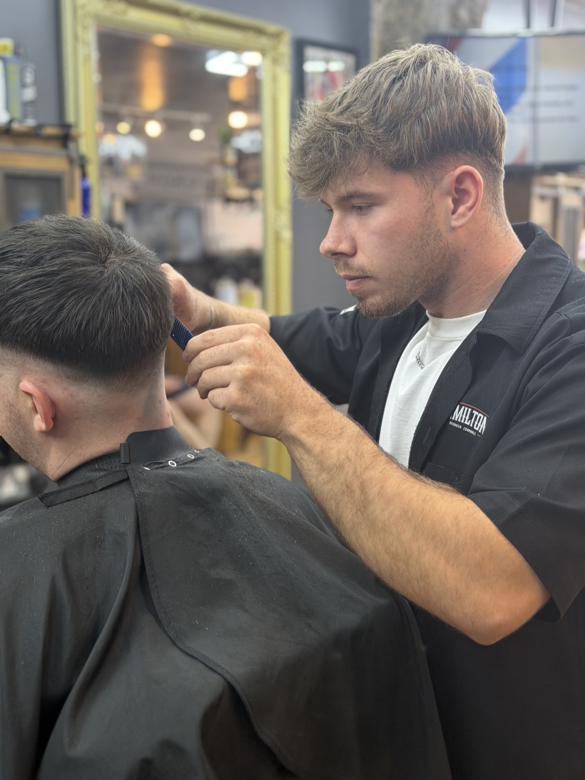 A barber clipper-cutting hair in the shop