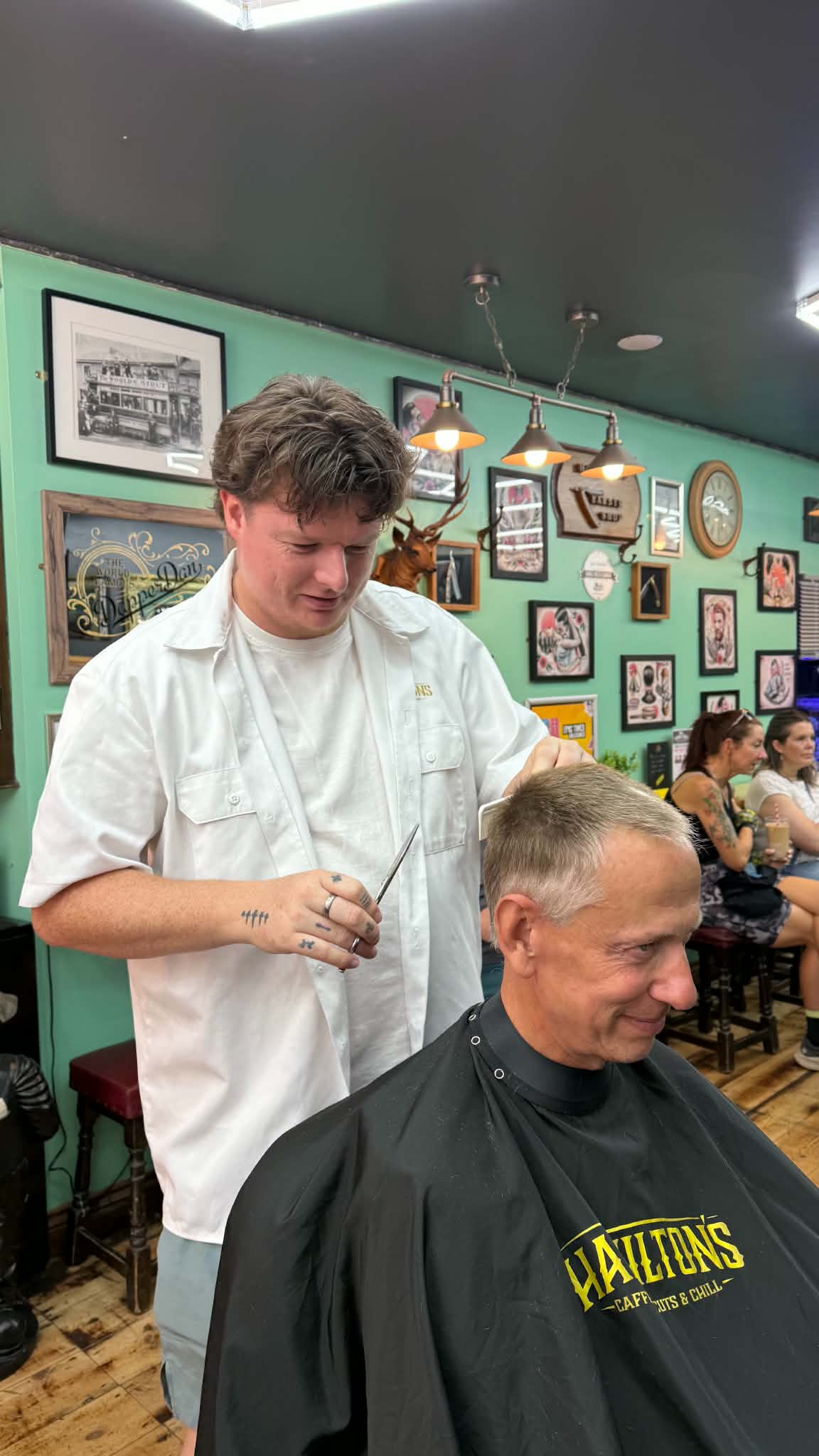 A barber cutting an older man's hair in the barbershop